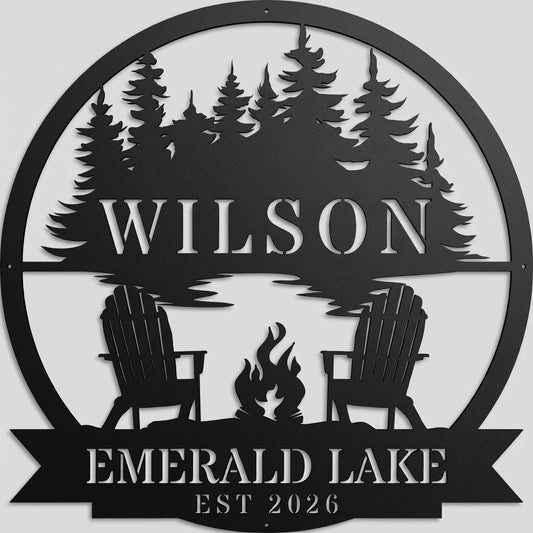 Custom campfire by the lake metal wall art sign in powder-coated matte black, featuring pine trees, chairs, and personalized text, mounted on a light gray studio wall.